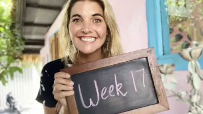 Abbey holding a chalkboard that says, "week 17"