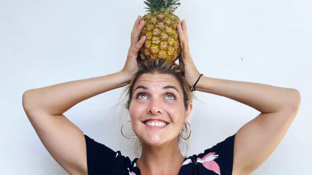 Abbey holding a pineapple on top of her head